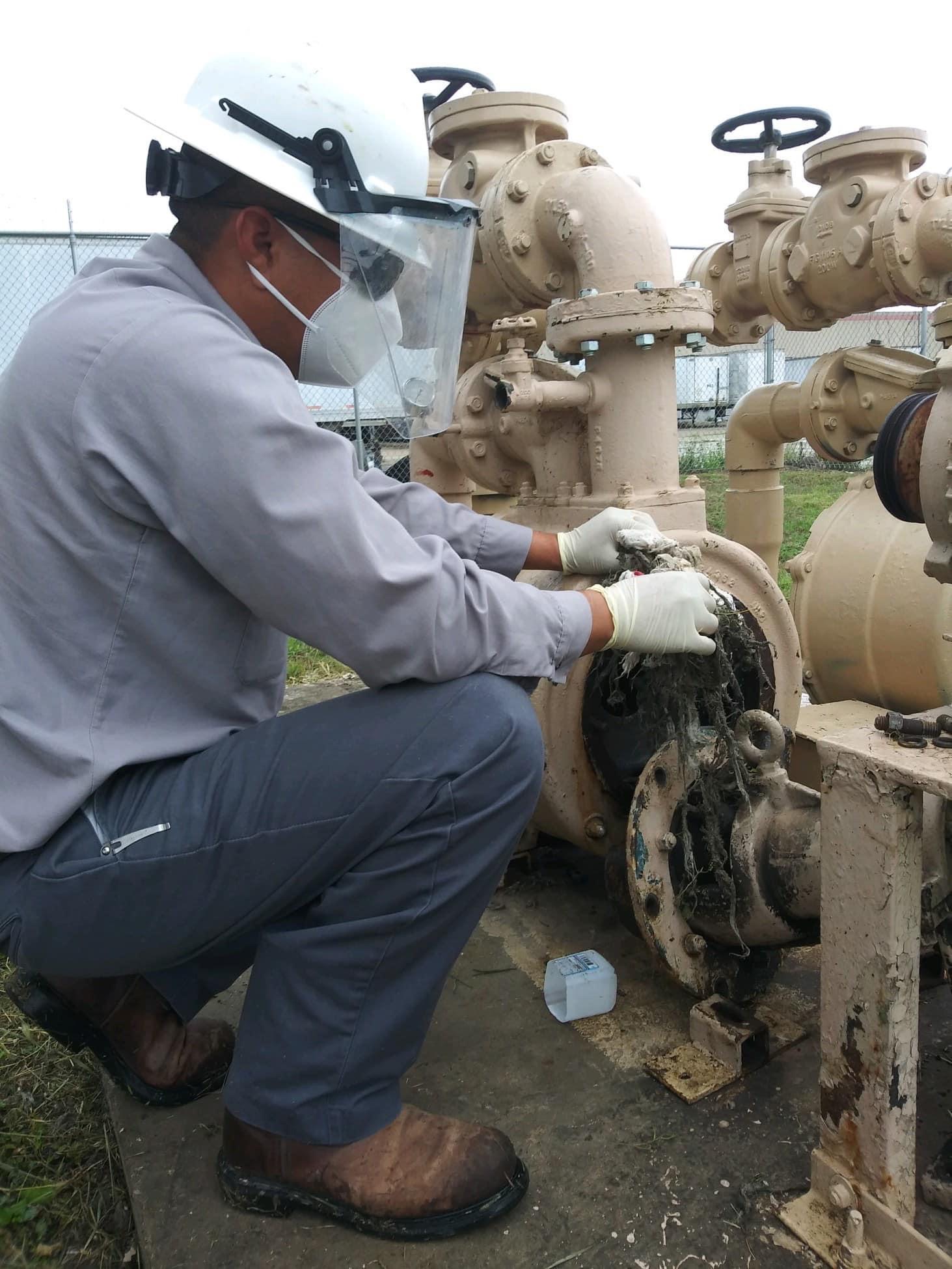 maintenance worker clearing clogged pipe