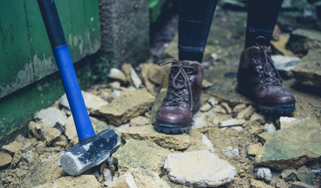 construction debris, sledge hammer, and boots