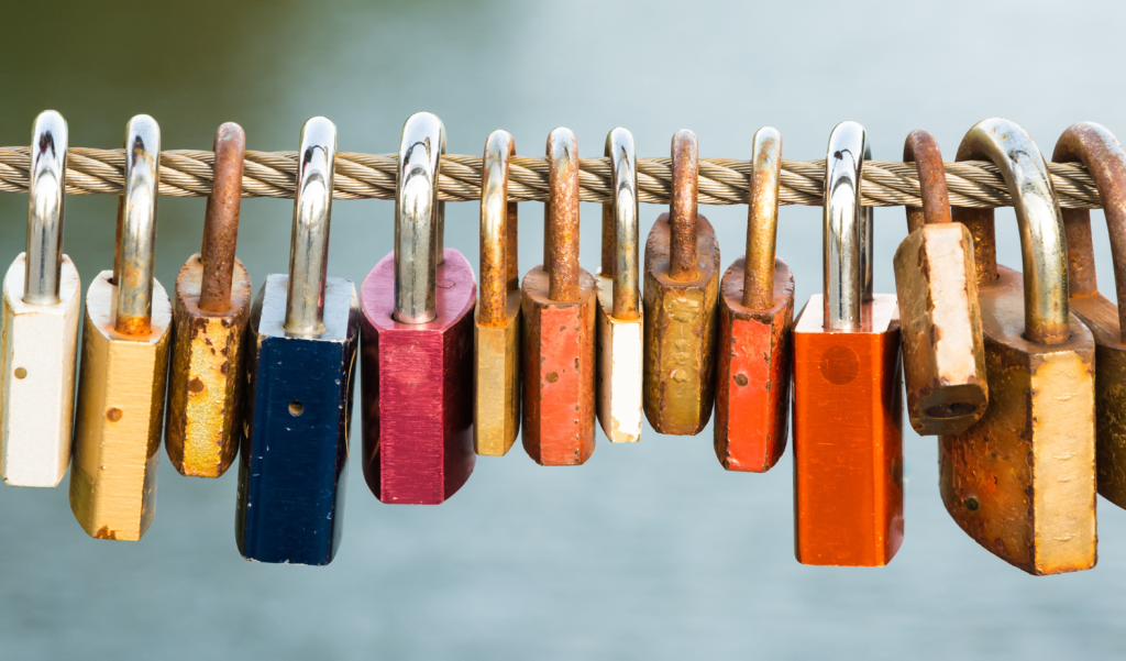 multiple padlocks hanging on a wire