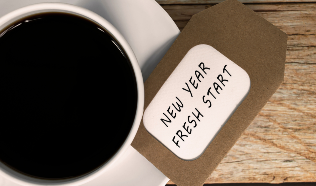 a cup of coffee with a note that says, "New Year, Fresh Start".