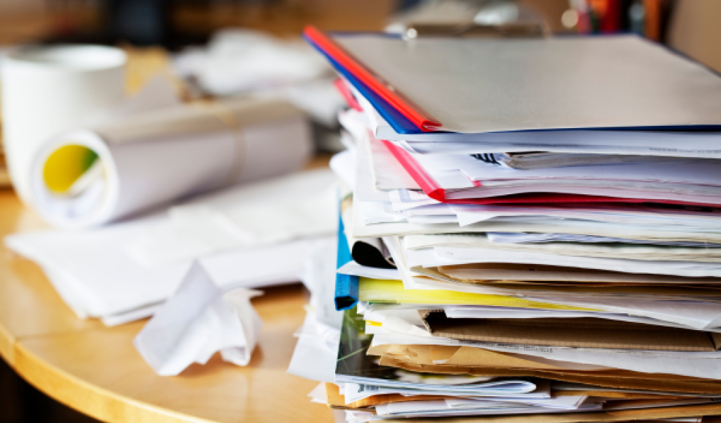 messy paper stack on desk 