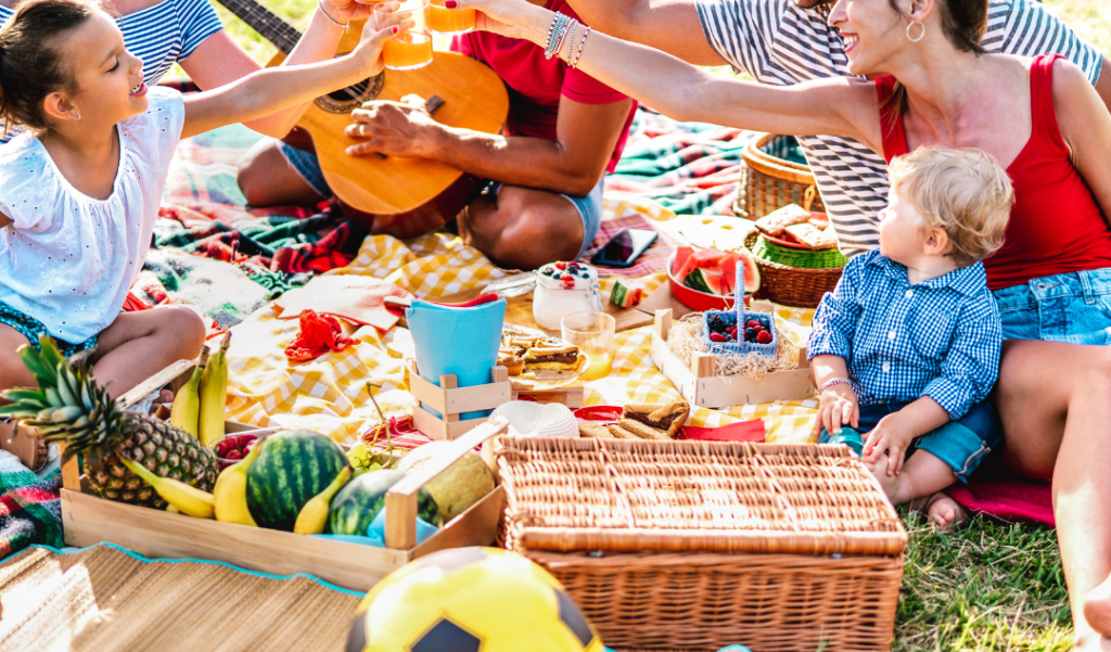 A group pf people happily picnic outdoors