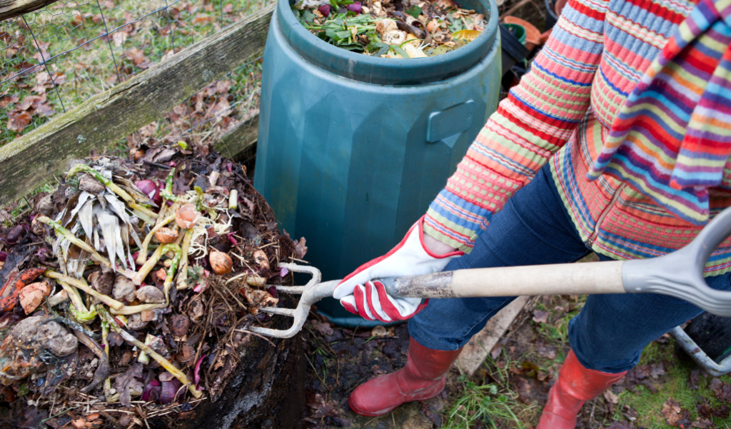 Person turning a compost pile.