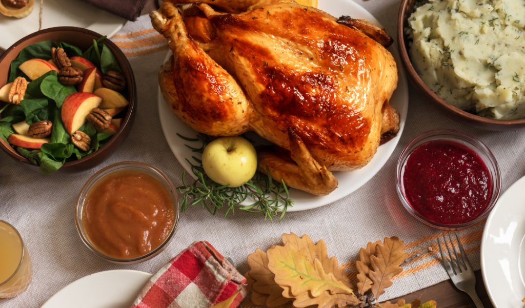 A table set up with a large turkey and a variety of side dishes. 