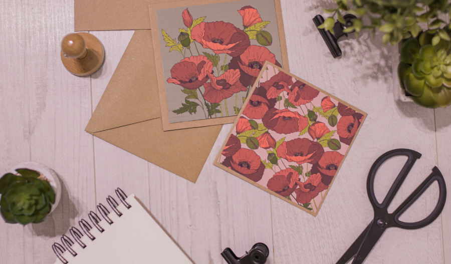 Notecard covered in red flowers near craft tools.