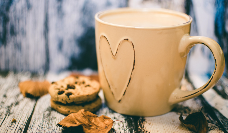 Mug with a heart carved in it next to cookies.