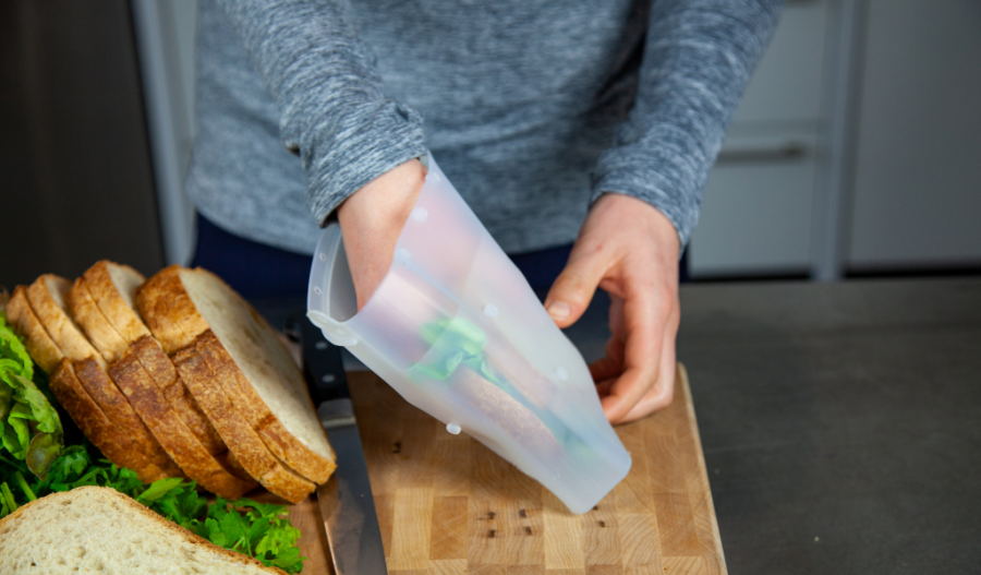 Person placing a sandwich in a reusable sandwich bag