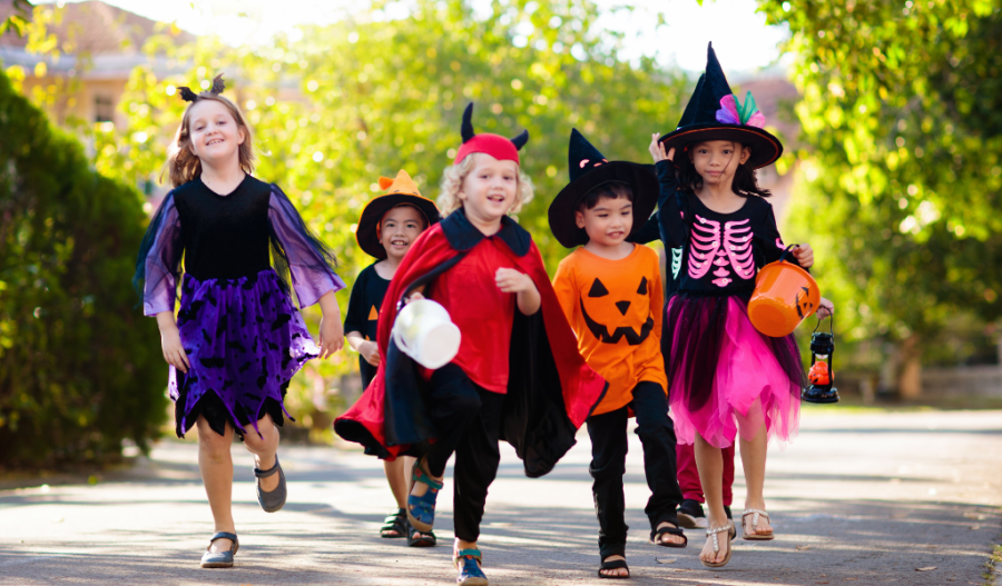 Children in Halloween costumes walking down the street