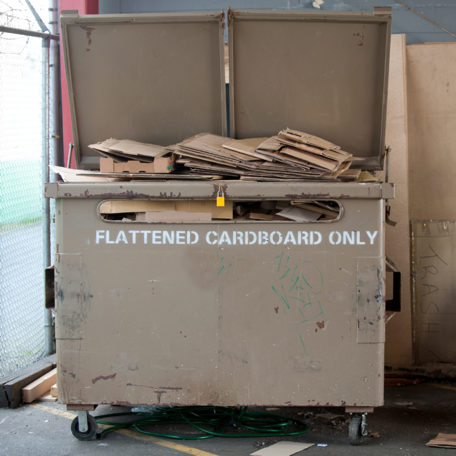 Dumpster with flattened cardboard boxes.