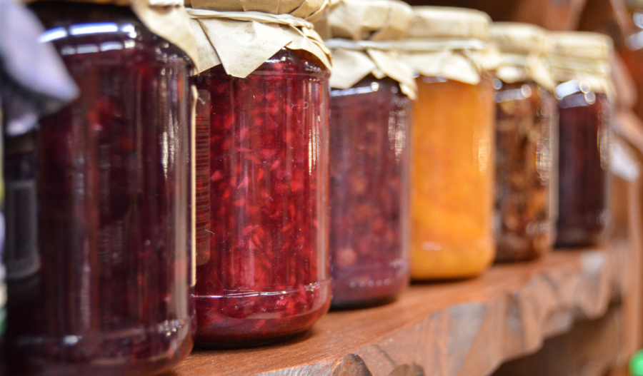 Various fruits being jarred in a pantry