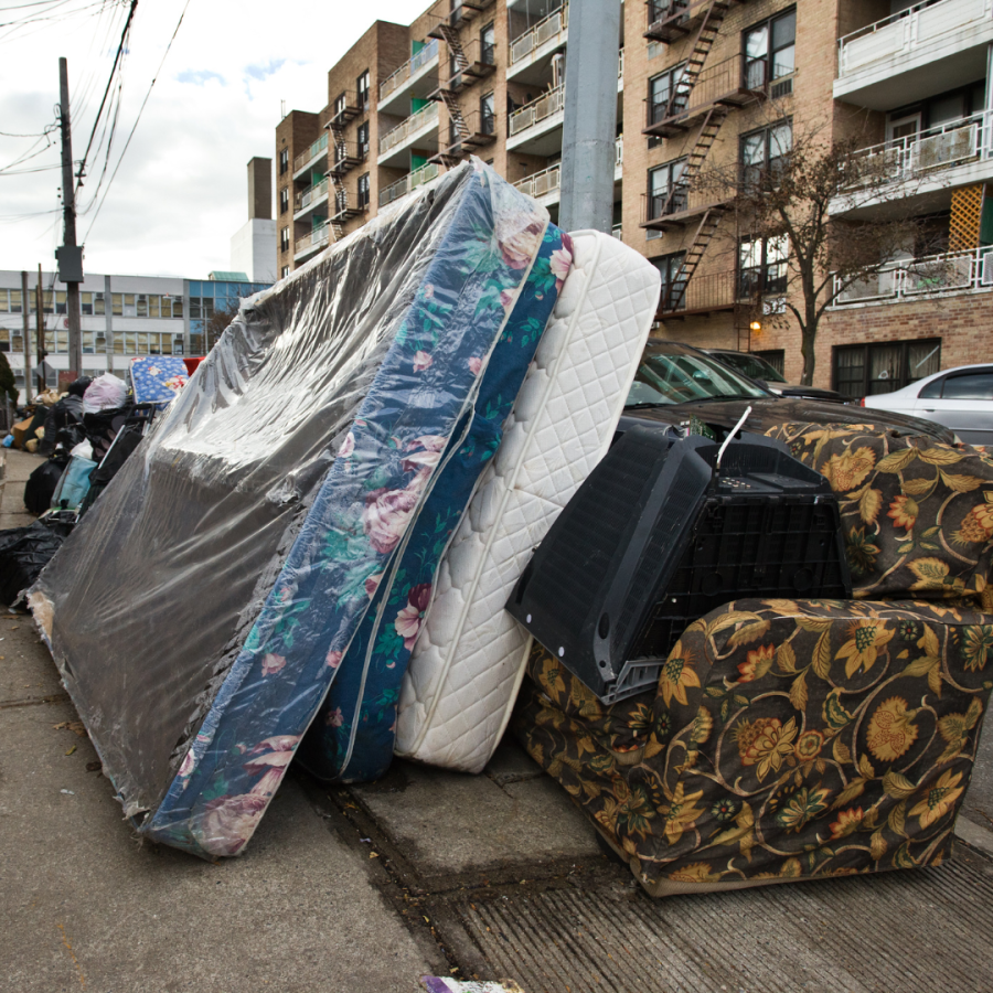 Mattresses and furniture dumped outside.