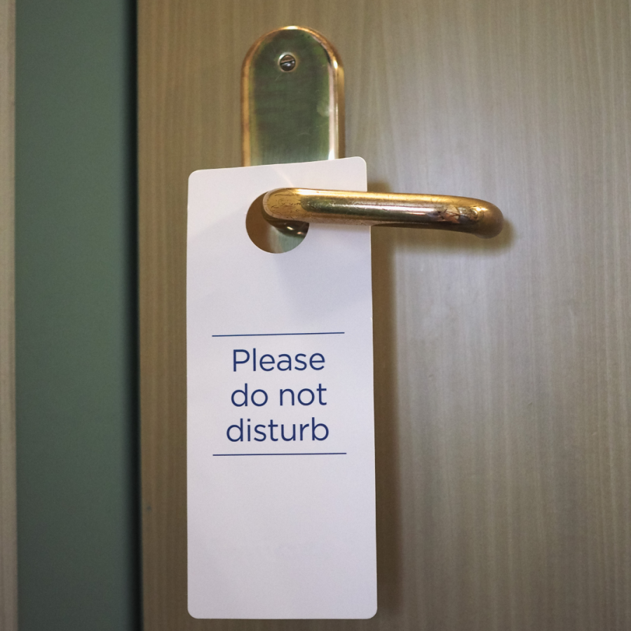 Hotel room door with "Do Not Disturb" sign on it.