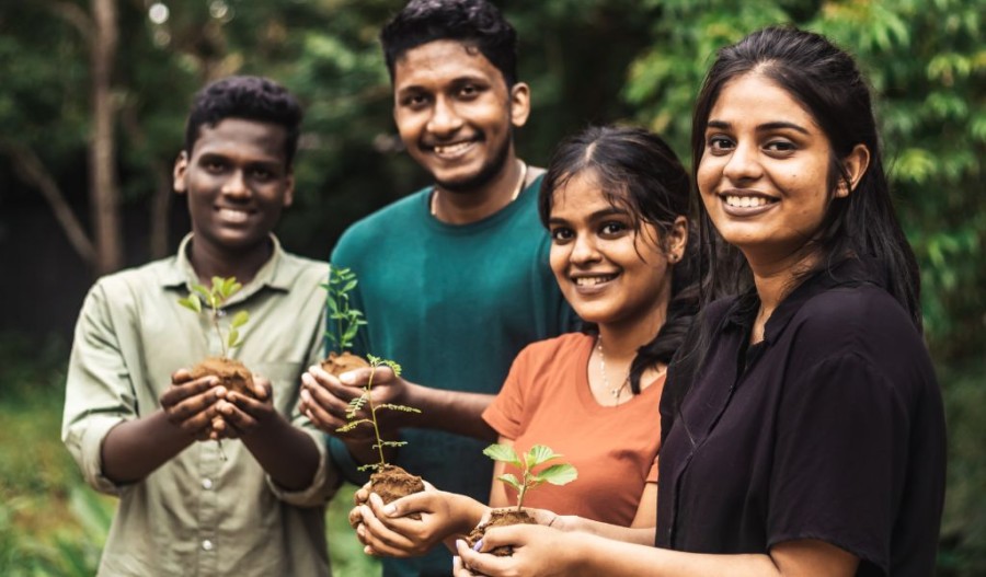 Students holding tree saplings.
