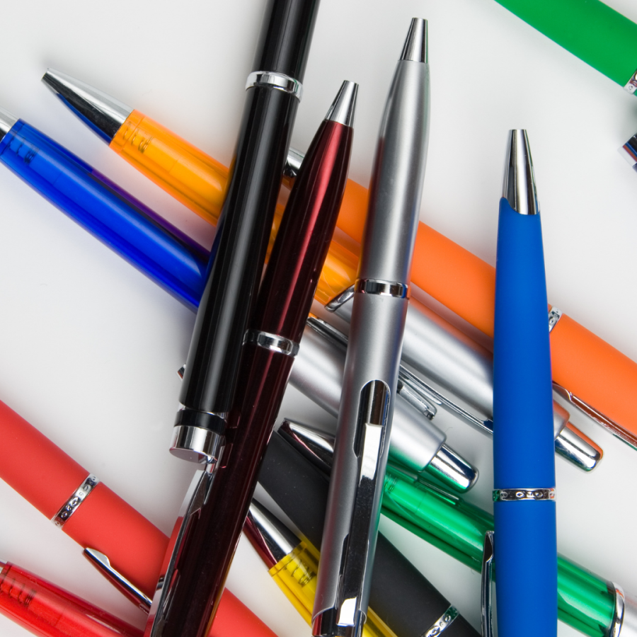 an array of mixed colorful pens scattered on a desk 