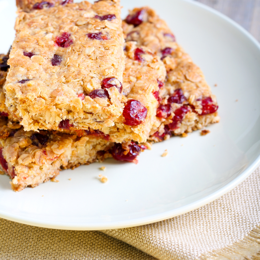 A plate holds three large cranberry oatmeal bars. 