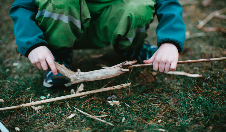 Young child picking up sticks