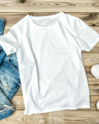 White t-shirt laying on a wooden table.