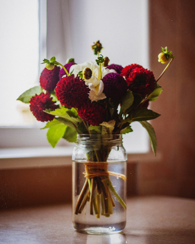 Flowers in an upcycled sauce jar.
