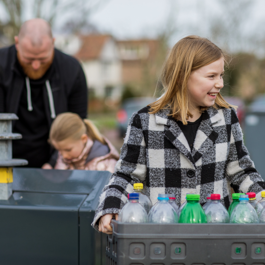 A father and daughters gather plastics to recycle.