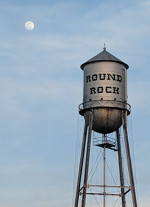"Round Rock" water tower beneath the moon