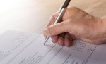 Hand holding pen writing on survey