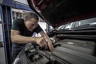 mechanic maintaining vehicle engine